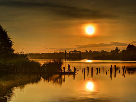Sunrise on the bon secour river with boathouse