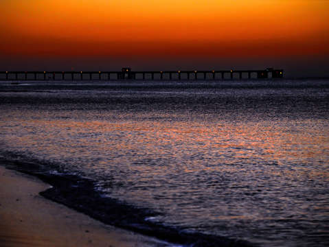 Orange sky over gulf state pier