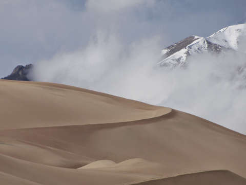 Sand dunes snow capped mountains