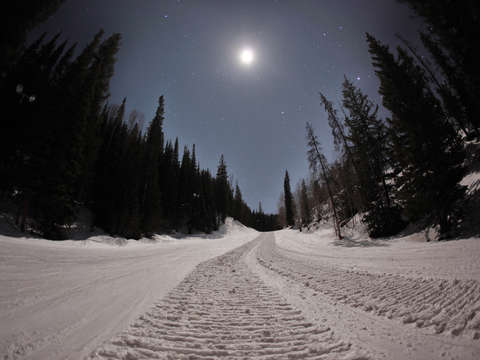Snow grooming machine tracks at night