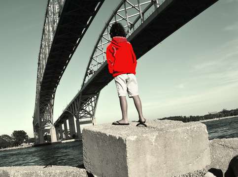 Boy in red under bridge