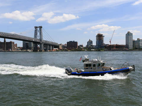 Police boat in front of williamsburg bridge
