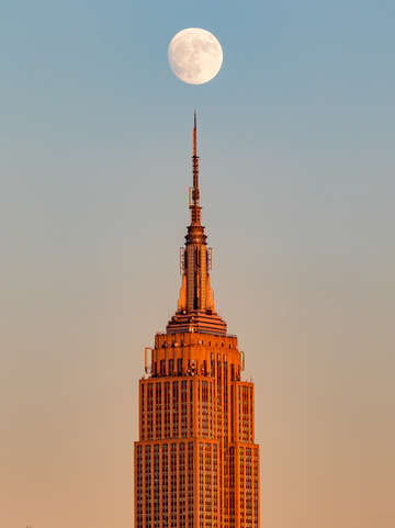 Moon rising above empire state building