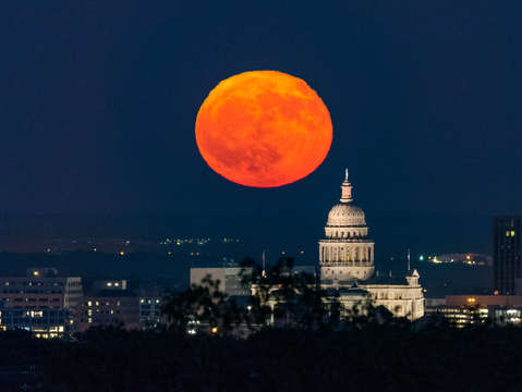 Full moon rise over the texas capitol