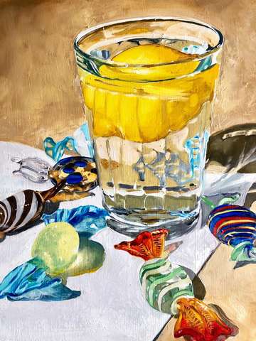 Lemon in glass of water with glass candies