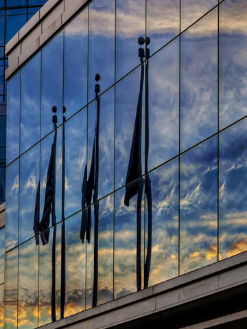 Reflected flags clouds and sky at sunset