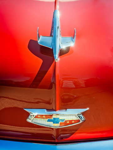 Hood ornament on a red 55 chevy