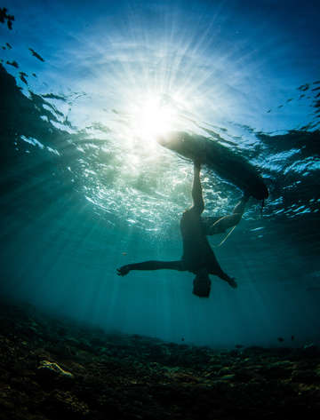 Underwater view of surfer at sunset 2