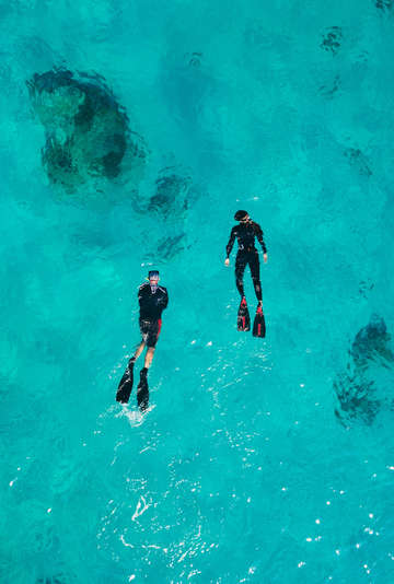 Aerial photo of snorkelers in a sapphire blue sea