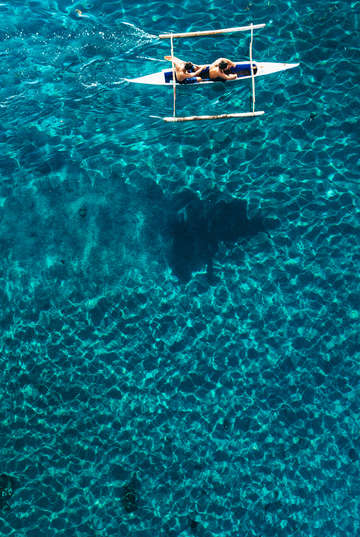 Aerial view of a sea kayak paddling across the blu