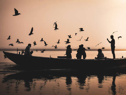 Boat and birds on river ganga at sunset varanasi i