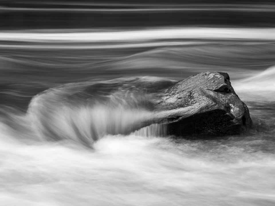Monochrome rock withstands the power of the river