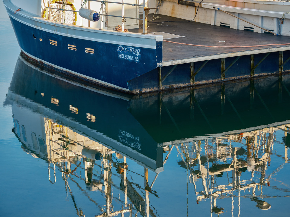 Reflections of a Fishing Boat on Calm Waters