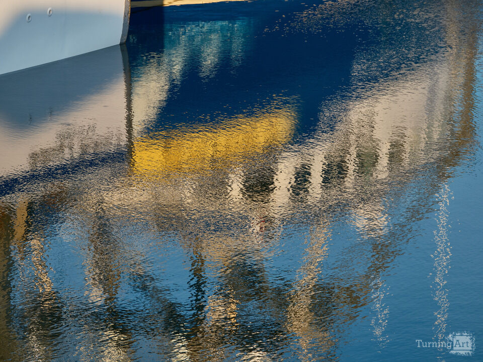 Rippled reflections of a colorful fishing boat