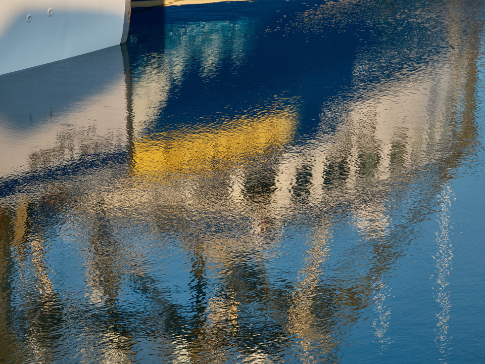 Rippled reflections of a colorful fishing boat