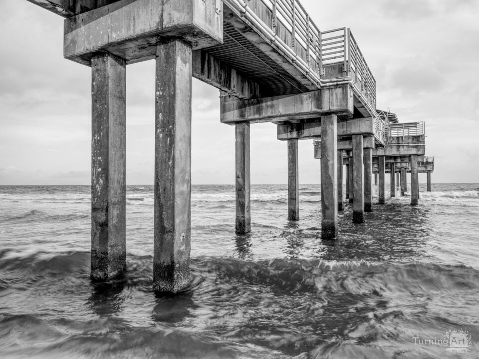 Rolling Waves Under Orange Beach Pier Grayscale