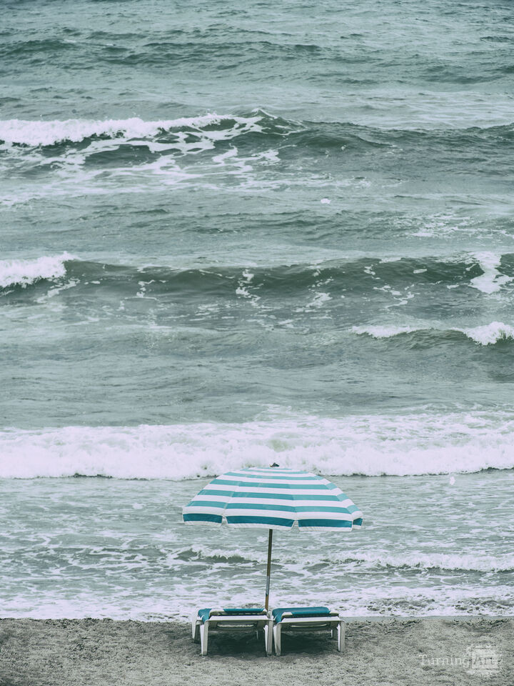 Turquoise umbrella and chairs on the beach