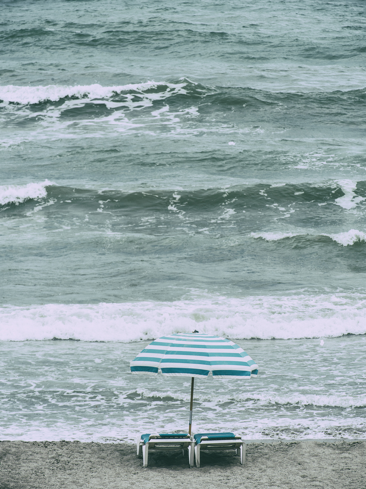 Turquoise umbrella and chairs on the beach