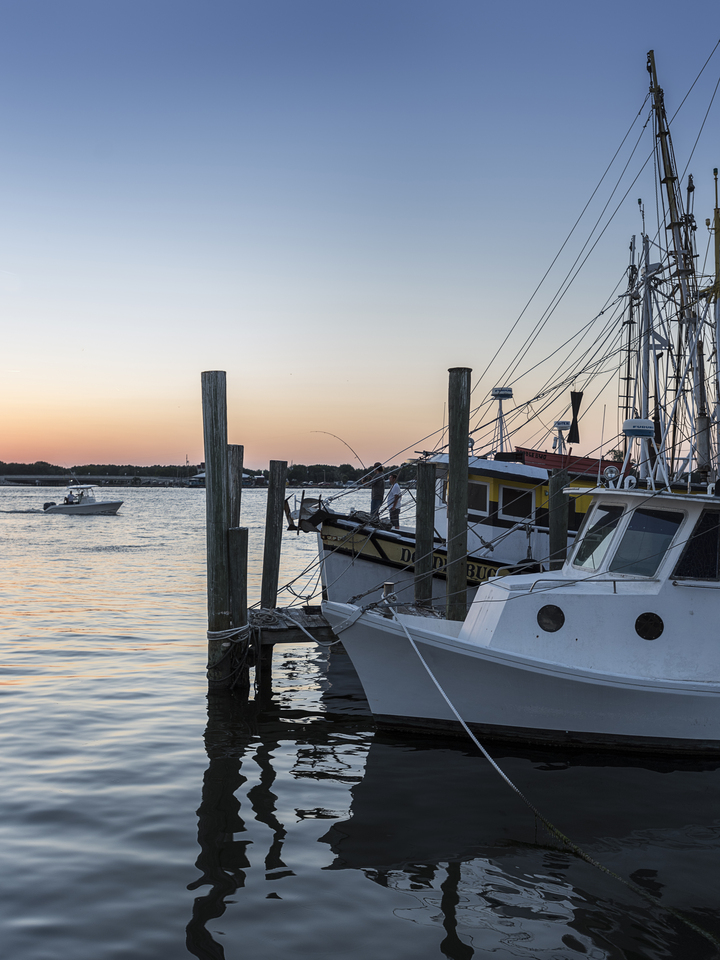 Boats and kayaks against a blue sky