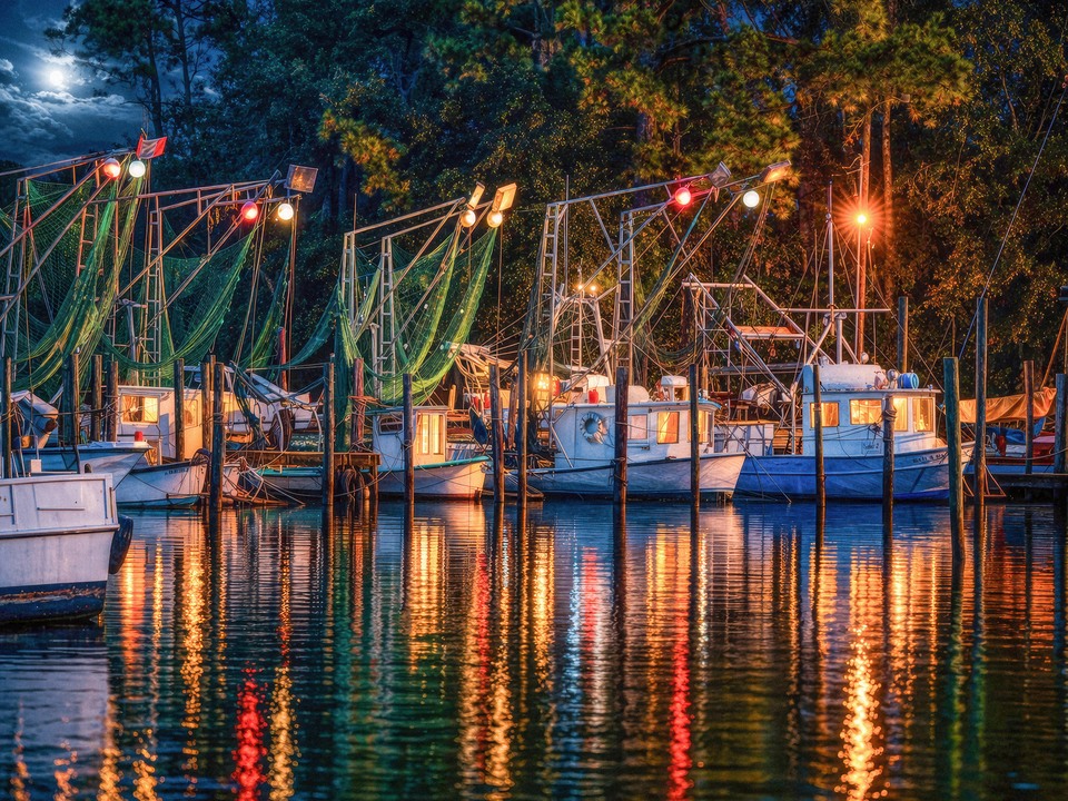 Coastal Fishing Boats at Night with Glowing Harbor