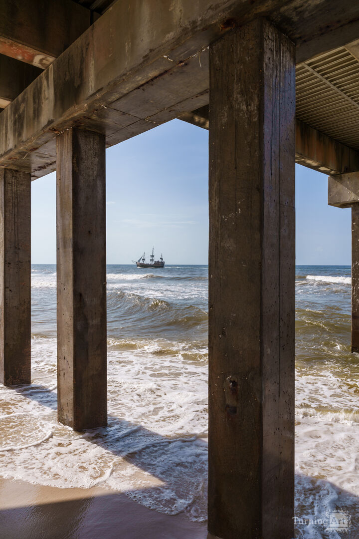 Pirate Ship View Under Orange Beach Pier Vertical