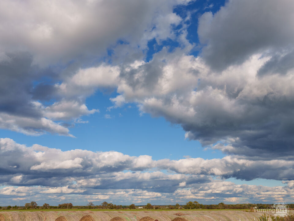 Hay Bales Beneath The Clouds