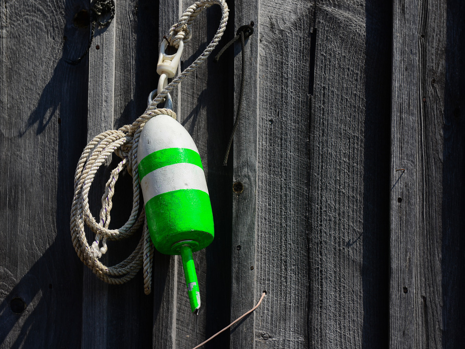 Green and White Lobster Float on a Weathered Shack
