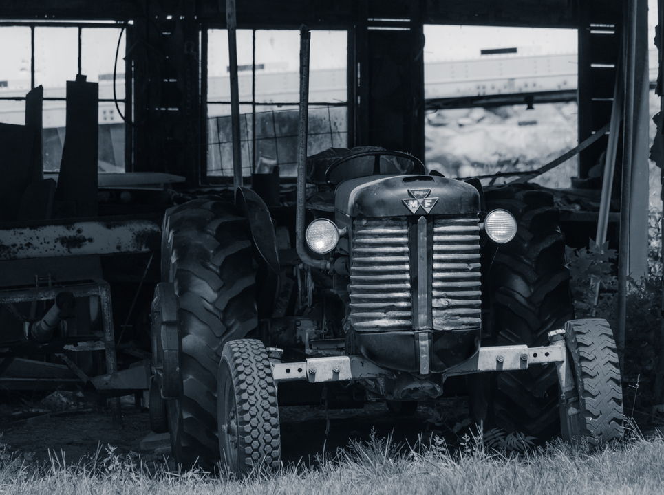 Old tractor in the barn black and white