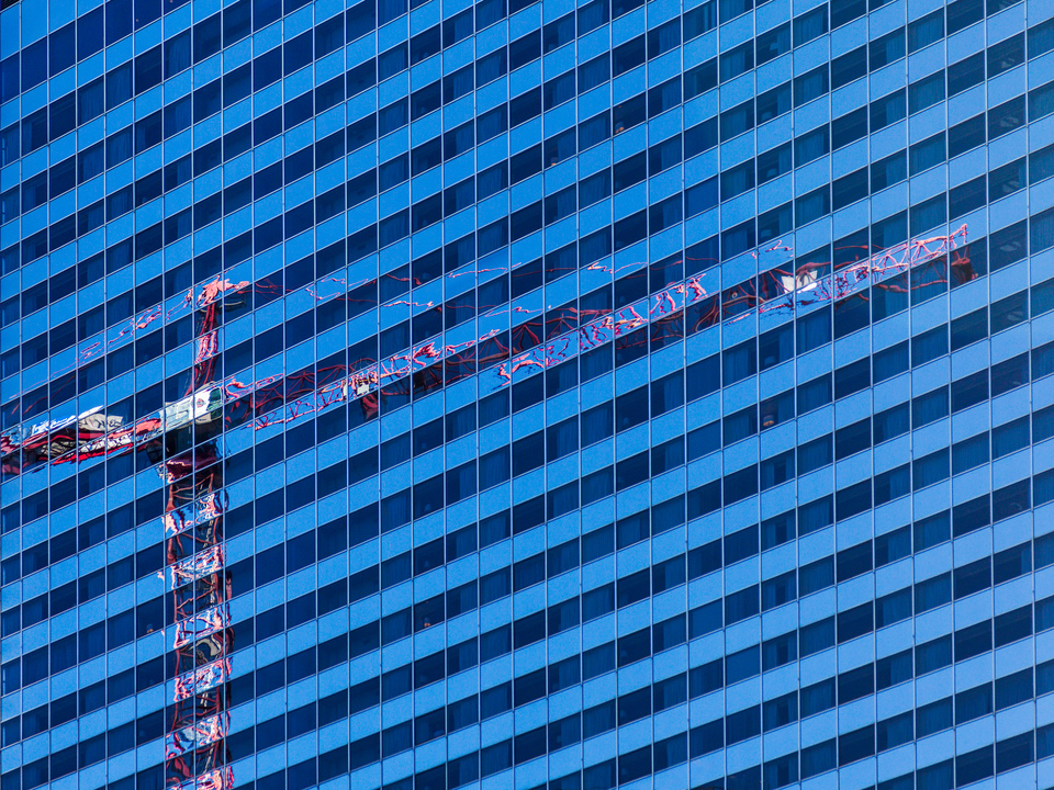 Reflection of crane in Chicago apartment building